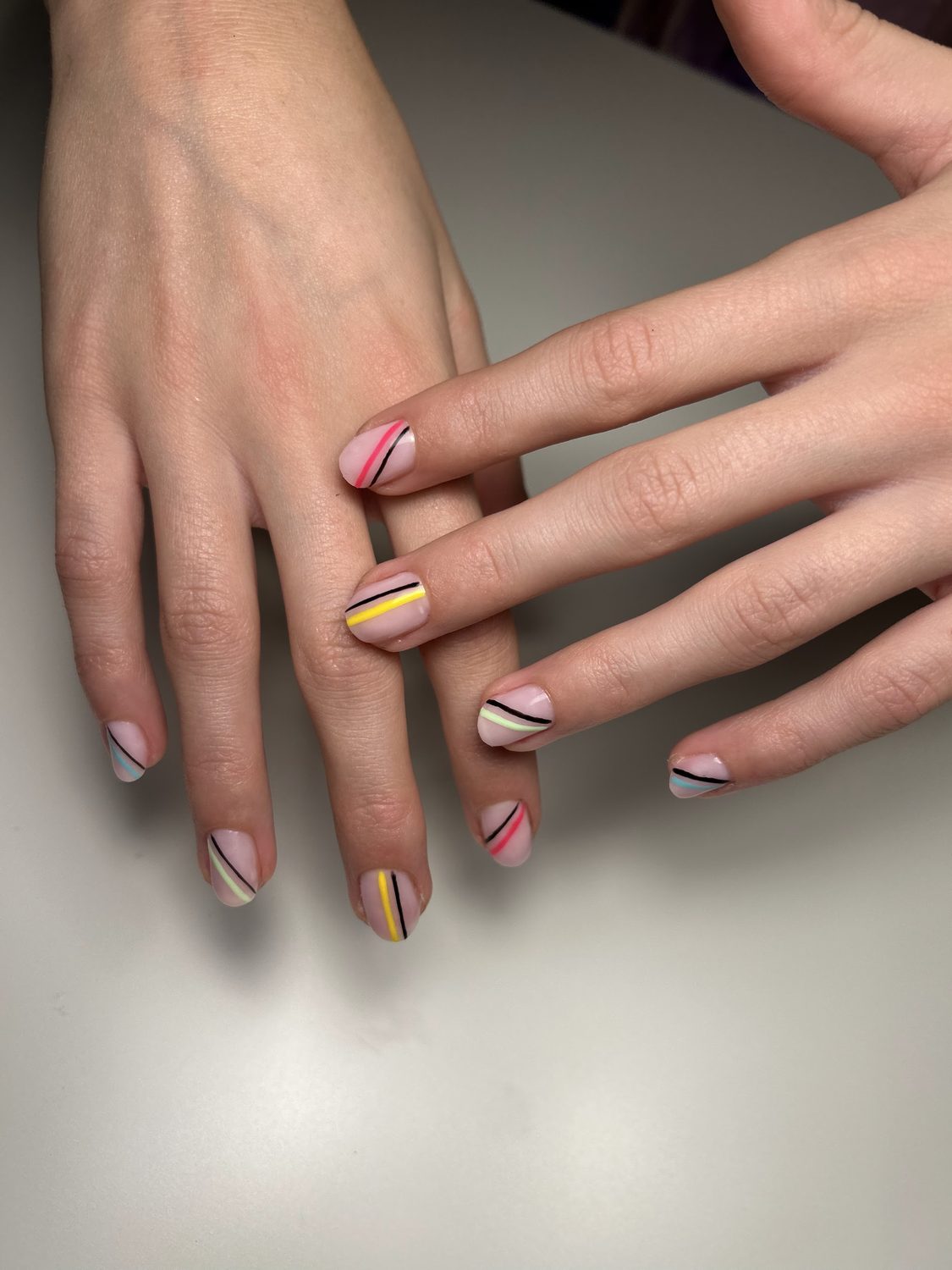 Naturel nagels met roze, gele en zwarte streepjes