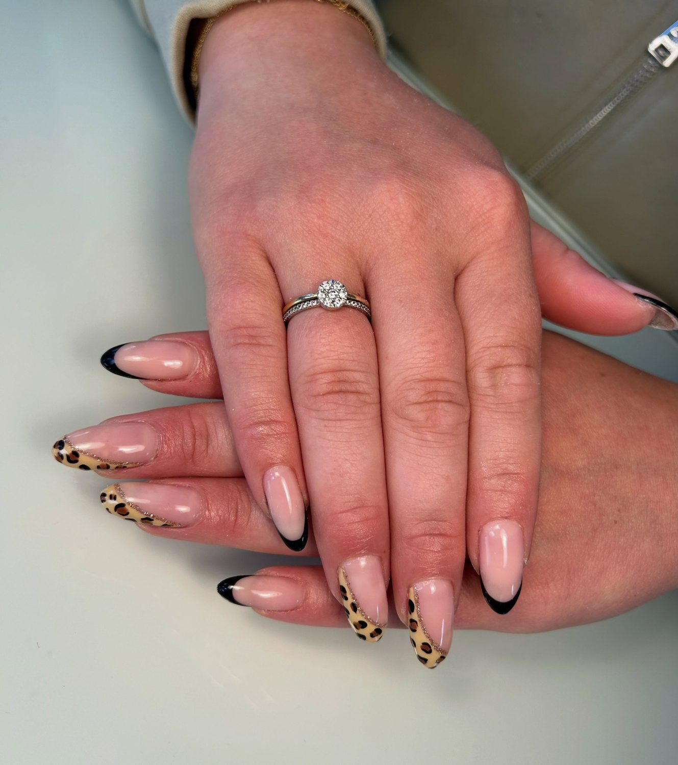 Nude nagels met een zwarte french en twee nagels in panterprint