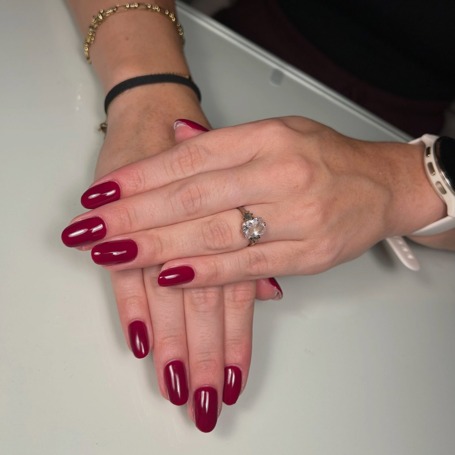 Glanzende bessenrode nagels, één hand over de andere